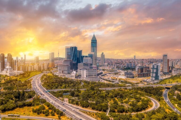 Panoramablick auf die moderne Skyline von Istanbul mit Hochhäusern, Autobahnen und farbenprächtigem Sonnenuntergang